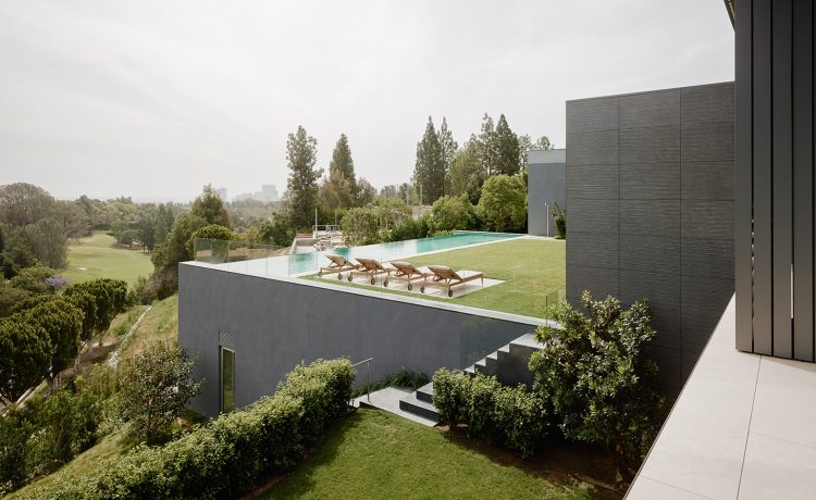 In the backyard, flower gardens bloom below spectacular views of LA and an infinity pool that faces downtown