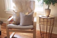 04 off-white Poang chair with pillows and a fur cover for a living room