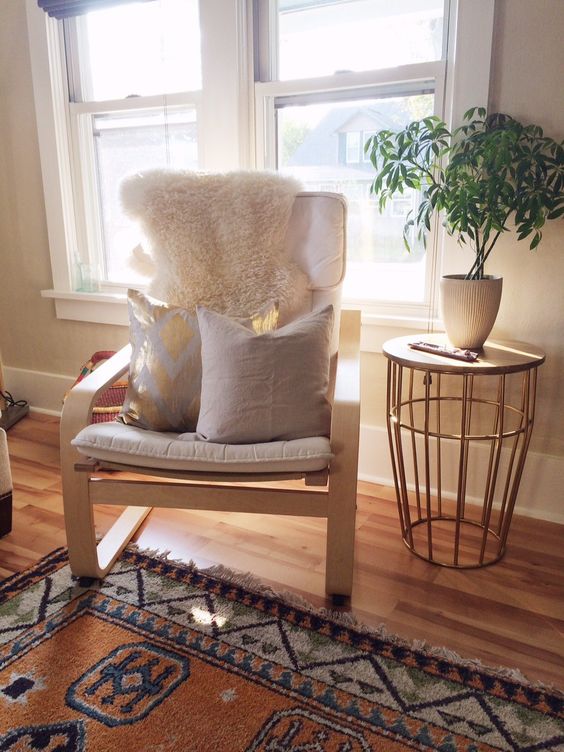 Off white Poang chair with pillows and a fur cover for a living room