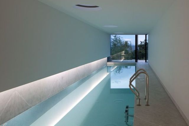 modern indoor narrow pool with lighting and a view