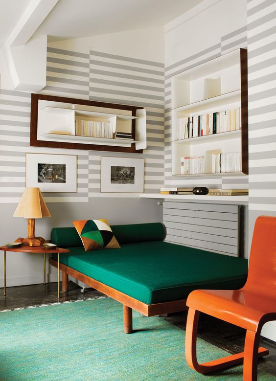 Striped walls and a bold green couch
