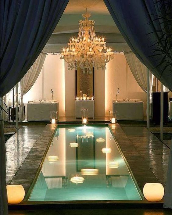 small indoor pool with lamps around and a stunning chandelier