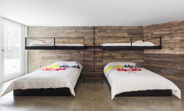 Reclaimed wood and earthy-colored concrete floor make this bedroom cozier
