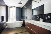 13 The bathroom is decorated in dark colors with the same black mosaic tiles as in the kitchen