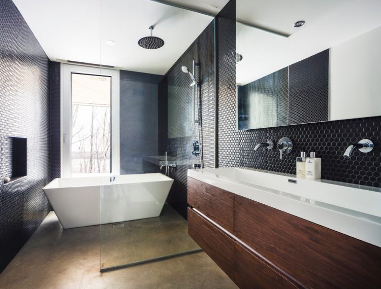 The bathroom is decorated in dark colors with the same black mosaic tiles as in the kitchen