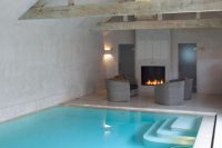13 blue indoor pool with a poolside fireplace and chairs