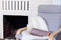 13 grey Poang chair with faux sheepskin and a log pillow