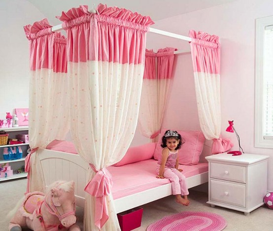 a pretty pink and white girl's bedroom with a canopy bed with color block curtains, white storage furniture and pink toys is super cute