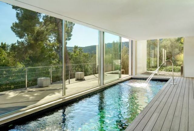 long and narrow indoor pool with a wooden deck and views