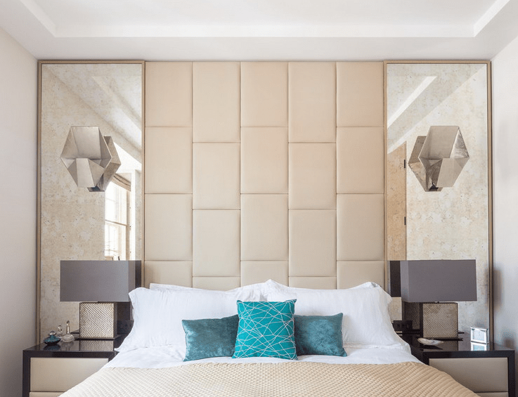 symmetrical mirrors with a leather headboard in-between
