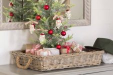 a tabletop Christmas tree decorated with red ornaments and Santa Claus heads is a fun and cool idea with a touch of vintage