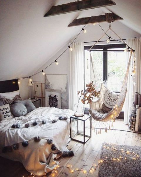 a boho attic teen room with a bed, a suspended chair, lights and lots of artworks is a lovely space to be