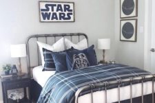 a Star Wars themed bedroom done in off-white and navy, with two tone bedding, signs, pillows and other small touches in decor