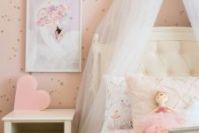 a blush princess room with a spotted accent wall, a white bed and a nightstand, a crown with a canopy is a lovely idea