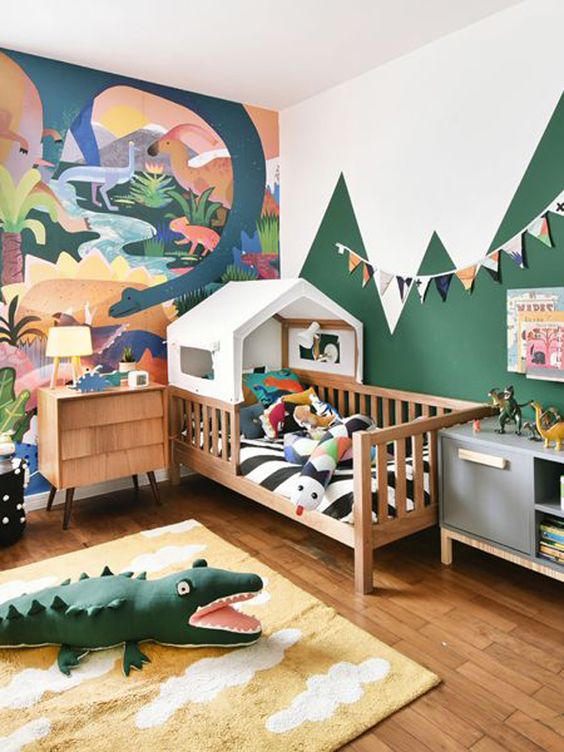 A bright and fun jungle themed kids' bedroom with a bold artwork, a house bed and colorful jungle inspired toys