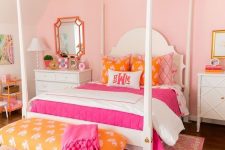 a bright pink girl’s room with a vintage bed with colorful bedding, a yellow bench with a pink blanket, a white chandelier and a pink printed rug