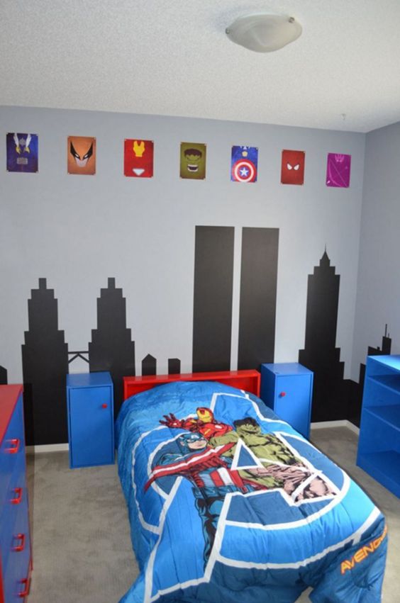 a colorful Marvel super hero themed kids' room done in blue, red and black, with emblems and bright bedding