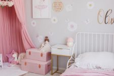 a dove grey girl’s room with white furniture, pink bedding, a pink teepee, pink suitcases and various toys is awesome