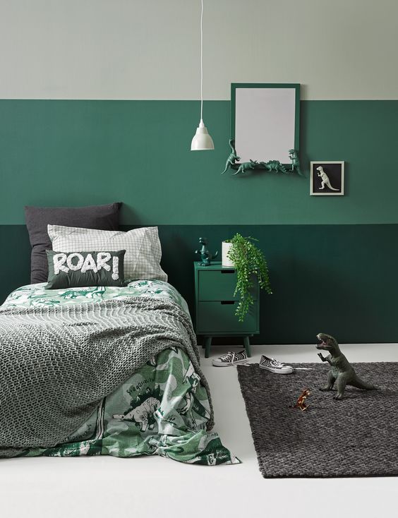 A fun mint and green dinosaur themed room with greenery, dinos and fun bedding is perfectly styled
