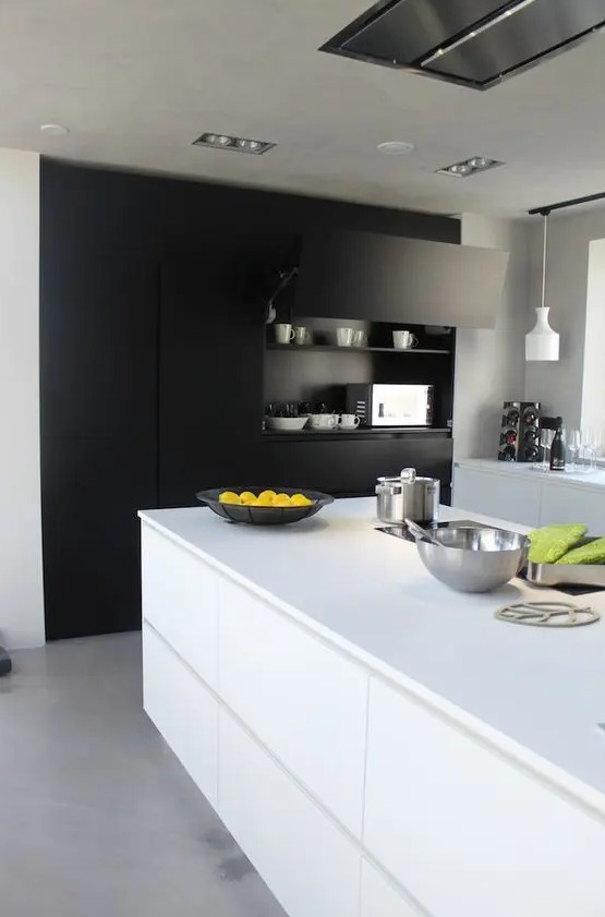 A contemporary black and white kitchen with a built in matte storage unit, sleek white cabinets and a kitchen island, pendant lamps and a lot of natural light