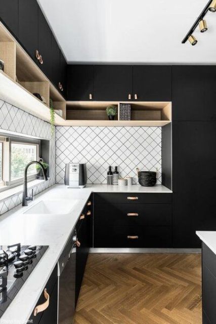 a mid-century modern kitchen with matte black cabinets, white stone countertops and a white geo tile backsplash, leather handles