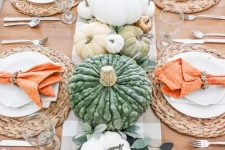 a bright and fun Thanksgiving table with leaves, pastel and whie pumpkins, woven chargers and orange napkins