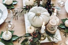 a neutral Thanksgiving table with white pumpkins, leaves, berries, candles and tree stumps and slices is very cool