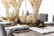 a rustic fall or Thanksgiving tablescape with a knit runner, pinecones, woven pumpkins, greenery and wheat is love