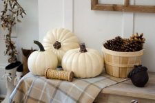 rustic entryway decor with cotton branches, pinecones, white pumpkins and a plaid runner for a cozy and rustic Thanksgiving feel