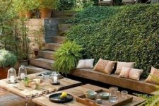 a modern Mediterranean outdoor living room with a built-in bench, modern furniture, wicker ottomans and lots of greenery