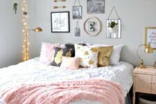a chic teen girl bedroom with grey walls, a large bed with printed pillows, a lovely gallery wall and lights over the bed