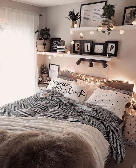 a cozy teen girl bedroom with a bed and printed bedding, shelves with lights and plants, books and magazines
