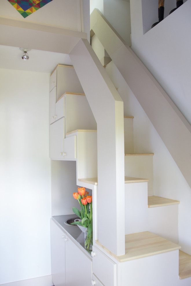 A compact ladder and a trapdoor designed in minimalist style provide access to the attic.