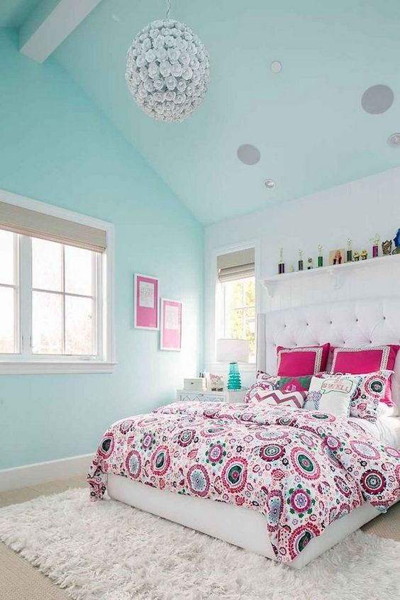 a bright and cheerful teen bedroom with an upholstered white bed, pastel mint walls and ceiling, a sphere chandelier and a shelf over the bed