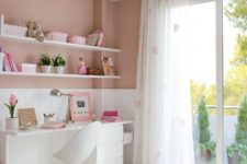 a contemporary pink teen bedroom with a white desk, heart print curtains, open shelves and a bed with pink bedding