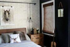 a contemporary teen bedroom with a dark and brick wall, wooden furniture, metal fans and neutral textiles