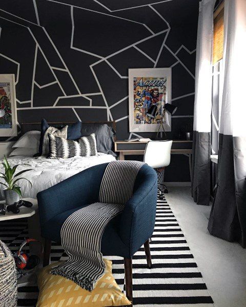 a contemporary teen bedroom with a graphic wall, a striped rug and pillow, color block curtains and a desk in the corner