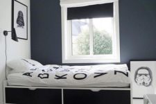 a laconic contrasting teen bedroom with black and white walls, a bed with drawers, black and white shades and artworks