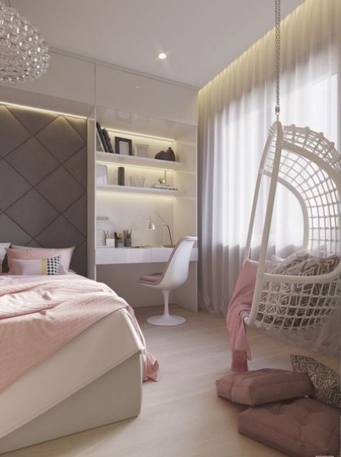 a pastel teen bedroom with a built-in bed, a built-in desk space and a hanging woven chair in the corner