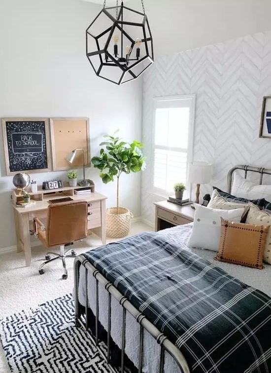 a stylish farmhouse teen room with a metal bed, lots of pillows, a small desk and a leather chair plus a faceted pendant lamp