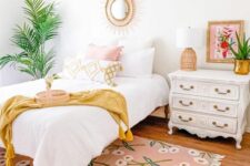 a tropical teen bedroom with a bed with neutral bedding, a pink printed rug, a white inlay dresser, potted plants