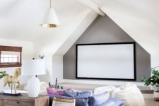 a cool attic home theater with a large screen, a blue sofa and creamy beanbag chairs, a stained console table and neutral chairs