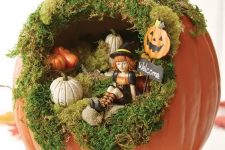 a cute Halloween diorama with moss, small pumpkins, a little witch and a black cat on top is a very fun solution for a kids’ party