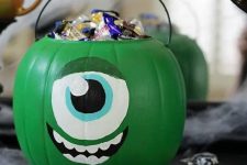 a green pumpkin monster filled with candies is inspired by Monster Corporation and looks super cool