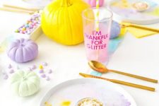 a super bold pastel Halloween tablescape with watercolor plates, pumpkins, drinks and candies