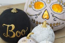 an arrangement of beautiful pumpkins – a matte black one, patterns ones and a gorgeous sugar skull styled pumpkin to finish off