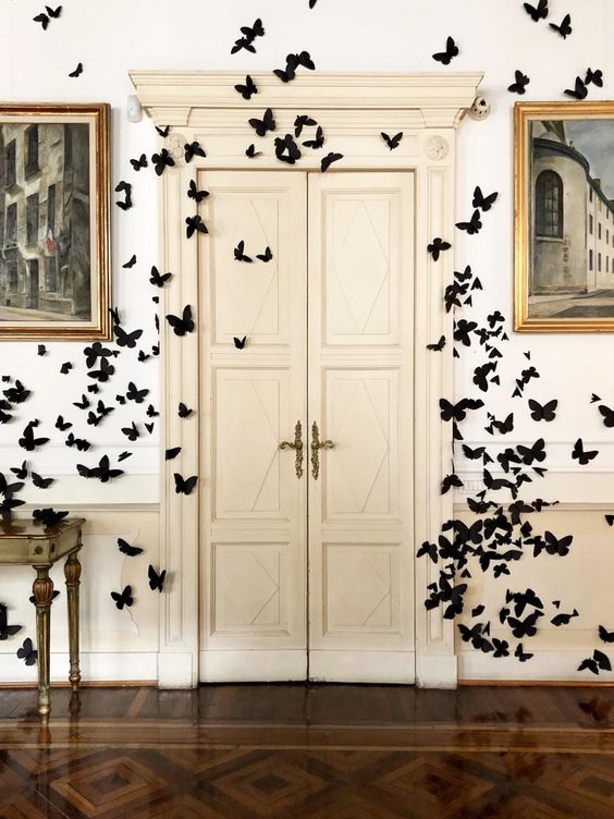 black paper butterflies all over the walls and doors are amazing to give a Halloween feel to the space