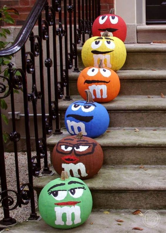Colorful M&Ms pumpkins are a funny and crowd pleasing idea that will attract attention to your space for sure
