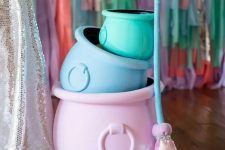 pastel-colored cauldrons and a broom fro styling a fun adult or a sweet kids’ Halloween party
