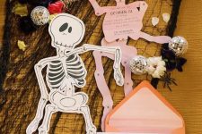 skeleton-shaped invitations in pink andorange envelopes will be afun and cool idea for both a kids’ and adults’ party